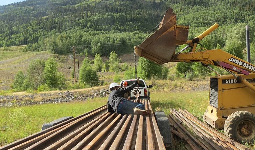 A full trailer load of rail from the Ridgway Railroad Museum is unloaded at the Silverton Northern construction site.