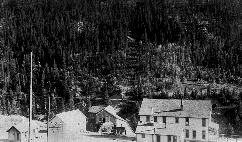 Office buildings for the Contention Mill with the water flume for the Silver Lake Mill across the Animas River.